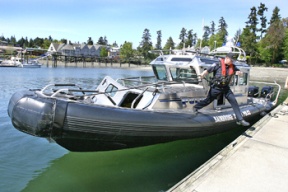 Bainbridge Deputy Police Chief Mark Duncan leaps from the new 33-foot police boat at Queen City Yacht Club in Winslow. The $647