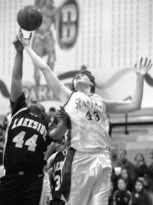 Megan Burris goes high for a rebound against Lakeside’s Jamila Humphrie during action Friday evening at Paski Gym.