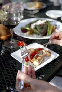 A Cafe Nola diner digs into a salmon skewer with fresh-picked tomatoes. The restaurant’s patrons are frequently served foods grown at the island’s Butler Green Farms.