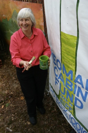Sonya Marinoni of the Bainbridge Community Endowment adds a swath of paint to show the growth of the Yeomalt Cabin restoration fund Monday. Growth of the fund