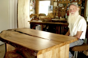 Wood artist Cecil Ross with the table he made from a very old elm.