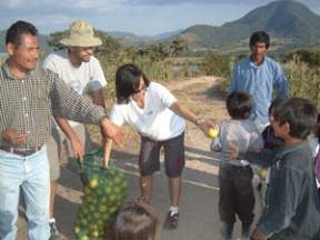 Scenes from a mission of service: Clara Tan and Zac Davis hand out fruit to the community of San Pedrito