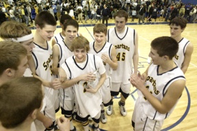 The team crowds around Paxton Kruse as he holds the 3A Sea-King District 2 trophy. Bainbridge defeated O’Dea 42-38.