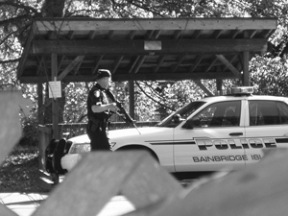 An officer works the perimeter of a Friday drug raid on a Lynwood Center Road home near Emerald Heights.