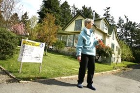 Barbara Winther of the city’s Historic Preservation Commission stands in front of a historic house at 292 Ericksen Avenue slated for demolition. Winther says the century-old house is an important part of the neighborhood’s historic character. The owners plan to replace the building with a mixed-used development