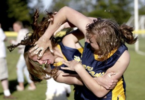Stephanie Wagner (right) and Anna Lyons partake in a cake fight after the last fastpitch game of the regular season Wednesday against Holy Names Academy.
