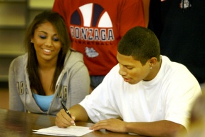 Steven Gray poses with his sister Brittany (left) and his parents (background.) The senior signed a letter of intent last Wednesday to play for the Gonzaga basketball team.