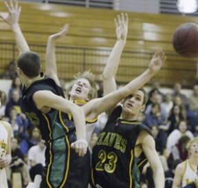 Austin Wood gets sandwiched in the Spartans’ 50-38 win over Blanchet Friday evening at Paski Gym.