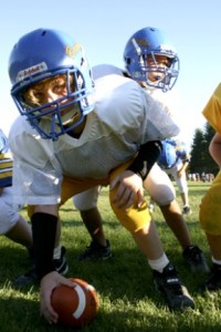 Cub-level quarterback Manny Dancel goes under center with Eric Norton (foreground) during offensive drills at Junior Football Association practice Thursday at Strawberry Hill Park.