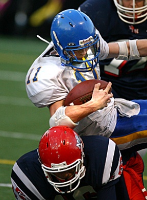 Spartan senior Nick Stone rolls over a Nathan Hale defender en route to his big 80 yard kick return during the Metro crossover game Friday night at Memorial Stadium in Seattle.