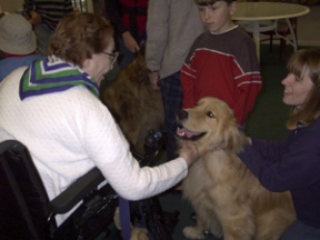 Kristi Hilst (right) and her golden retriever visit with a Wyatt House resident during a pet show organized by Cross Sound Church.