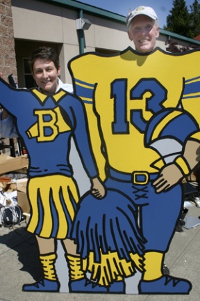 Joanne Ellis and Jon Carney suit up for the big game – the 46th annual Rotary Auction and Rummage Sale this Friday and Saturday at Woodward Middle School. The wooden cutout of a BHS football player and cheerleader is among the countless items – fine