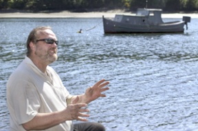 Erik Christensen sits on the shore of Blakely Harbor