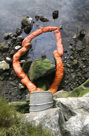 A stormwater drain at the base of Madison Avenue sits ready to pour another dose of runoff into Eagle Harbor. The pipe is fitted with a boom to collect motor oils that trickle down the avenue.