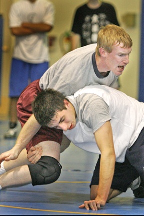 Head coach Dan Pippinger (top) wrestles senior co-captain Peter Paskell.