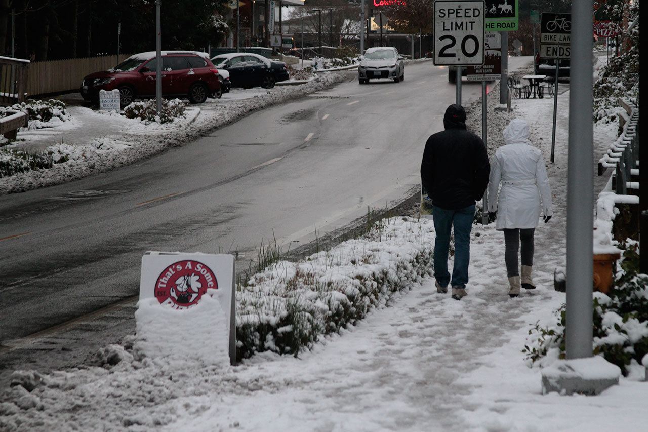 Luciano Marano | Bainbridge Island Review                                One stalwart couple brave the chill and the quickly-melting snow Friday morning for a walk downtown.