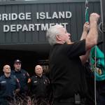 Luciano Marano | Bainbridge Island Review &mdash; Bainbridge Island Fire Department Battalion Chief Dave Hannon lowers the flag outside Station 21 for the last time, the department&rsquo;s headquarters having been relocated to Station 23 on Phelps Road for the duration of the construction of a new facility. Hannon began his career with the BIFD in 1975 as a volunteer at the Bucklin Hill Road station and served for the longest of any island firefighter at Station 21.