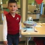 Photo courtesy of  Susan Kilbane                                Jayden Larios, 6, a kindergartener at Saint Cecilia School, stands with his creation, the grand prize winner at the school&rsquo;s recent 3-D &ldquo;Star Wars&rdquo;-themed recycled art show and photography competition.