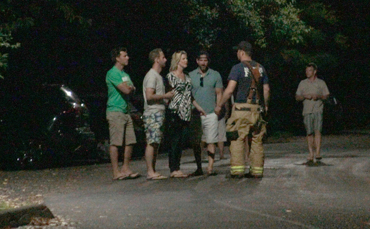 Luciano Marano | Bainbridge Island Review - A Bainbridge Island firefighter diverts pedestrians away from the area of Waterfront Park and the city dock Saturday night during the active shooter stand off, which ended early Sunday after the gunman was shot and killed by police.