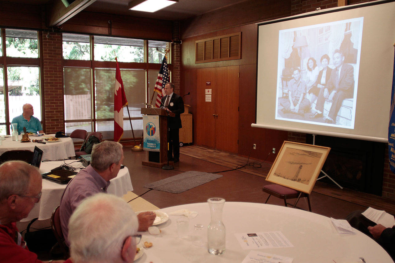 Luciano Marano | Bainbridge Island Review - Rotary Club of Bainbridge Island president Todd Tinker regales the gathered crowd of Rotarians and guests at a luncheon Monday with the saga of Chiura Obata&rsquo;s untitled painting of the Topaz Japanese American Internment Camp in Utah, which came to the Rotary as an anonymous donation during last year&rsquo;s auction and rummage sale.