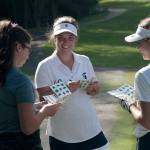 Luciano Marano | Bainbridge Island Review - Bainbridge High School girls varsity golf team cocaptains Maddie Loverich (center) and Sara Colley (right) review the course map with a visiting golfer from Eastside Catholic at the start of Tuesday&rsquo;s match.