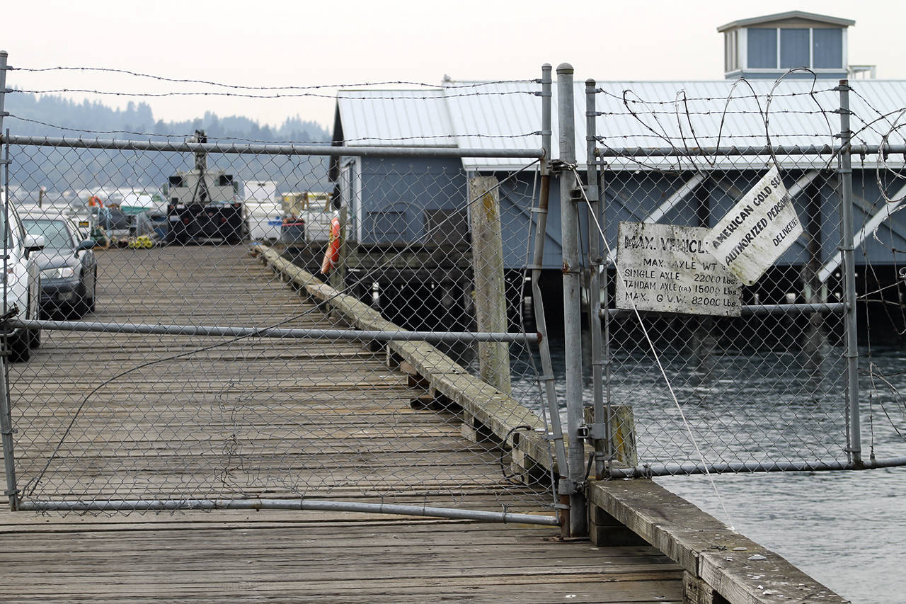 The entrance to the Cooke Aquaculture fish pens near the southern end of Fort Ward Park. Employees&rsquo; cars had been driven out onto the pier and the gates had been padlocked.                                Terryl Asla/Kitsap News Group