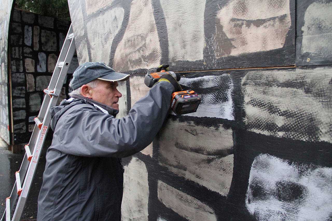 Charlie Wiggins helps put together the gateway arch for the Bethlehem Experience at Rolling Bay Presbyterian Church. (Brian Kelly | Bainbridge Island Review)