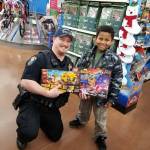 Bainbridge Police Officer Chuck Kazer helps shopper Emmanuel Rivas, 9. (Photo courtesy of the Bainbridge Island Police Department)
