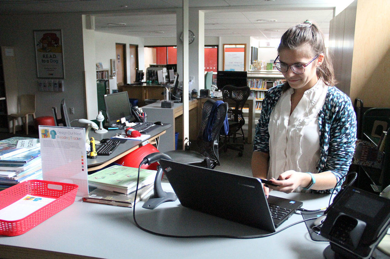 Lisa Racine, youth services librarian at the Bainbridge Public Library, tries to get on the internet without success during Tuesdays power outage. The library remained open during the outage. (Brian Kelly | Bainbridge Island Review)