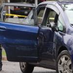 An officer stands next to the car that was driven by a man they say entered Bainbridge High Wednesday and assaulted students. The fleeing suspect was stopped after police rammed his vehicle on Wyatt Way.