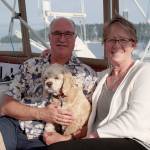 Luciano Marano | Bainbridge Island Review - Scott and Laurie Isenman aboard their boat with their dog Teddy.