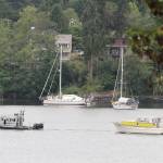 Bainbridge police tow a derelict vessel out of Eagle Harbor late last week. (Brian Kelly | Bainbridge Island Review)