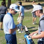 Luciano Marano | Bainbridge Island Review - Members of the Bainbridge High School boys varsity golf team exchange score cards before a practice round.