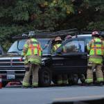 Bainbridge Island firefighters work to remove an injured driver from his pickup truck after a two-vehicle crash on Highway 305 on North Bainbridge Monday morning. (Brian Kelly | Bainbridge Island Review)