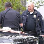 Bainbridge Police Chief Matthew Hamner gets briefed by a Bainbridge police officer at the scene of a death investigation late last year. (Brian Kelly | Bainbridge Island Review)