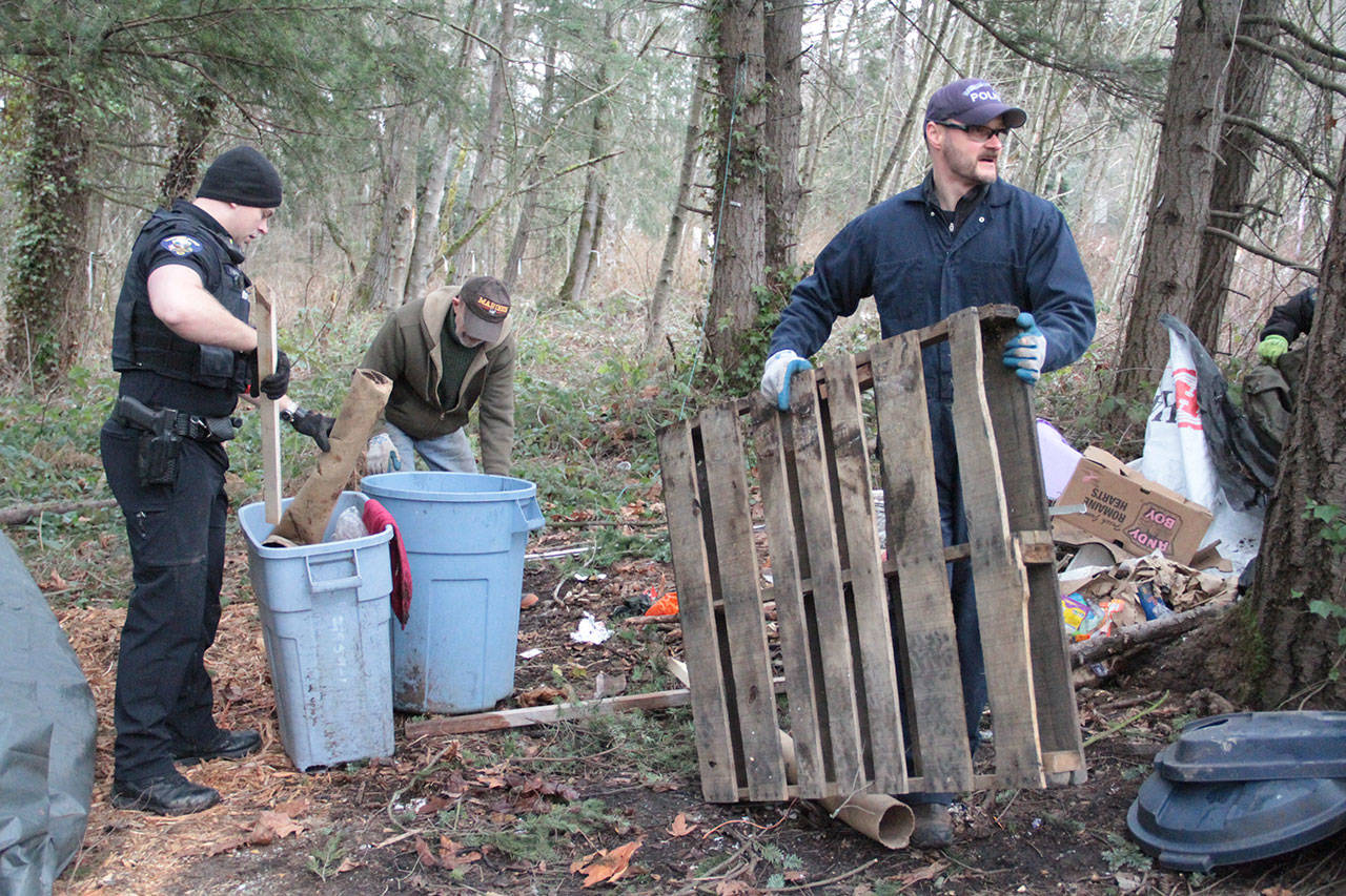Bainbridge police work to clean up the site of a former homeless camp next to Highway 525 Monday morning.                                (Brian Kelly | Bainbridge Island Review)