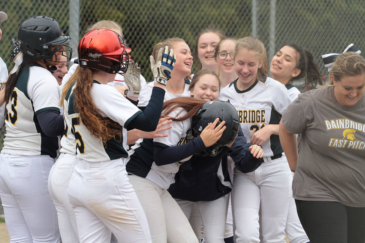 Ruby Raymundo is mobbed at home plate after she hit a two-run homer against Seattle Prep in last weeks fastpitch softball matchup. (Brian Kelly | Bainbridge Island Review)