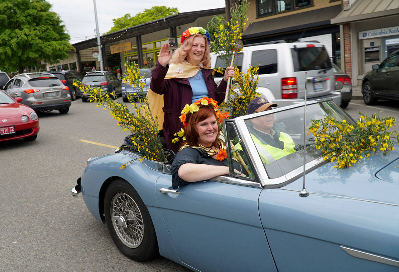 Luciano Marano | Bainbridge Island Review - This years Scotch broom queen, Jennifer Carrillo, rides shotgun in the quirky annual impromptu parade Wednesday, May 15, while prior queen Mickey Molnaire rides up top.