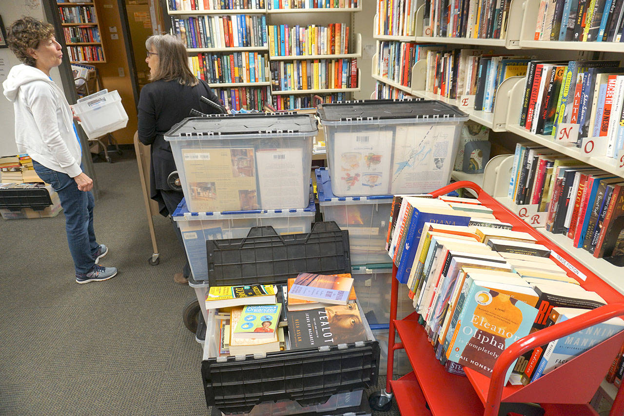 Luciano Marano | Bainbridge Island Review - Lois Reitz, president of the board of the Bainbridge Island Friends of the Library (left) talks with longtime volunteer Daphne Stewart during a sorting/shelving session earlier this week in preparation for an upcoming book sale at the Bainbridge Public Library.