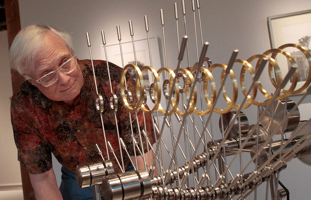 Luciano Marano | Bainbridge Island Review - Island engineer and artist Carl Morgan examines Because of Prairie Grass, one of 10 pieces on display at Bainbridge Arts & Crafts as part of his Nearly Newtonian series.