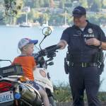 Luciano Marano | Bainbridge Island Review - Bainbridge Island Police Department Officer Gary Koon gives a young attendee a chance to sit on his bike during last years National Night Out event in Waterfront Park.