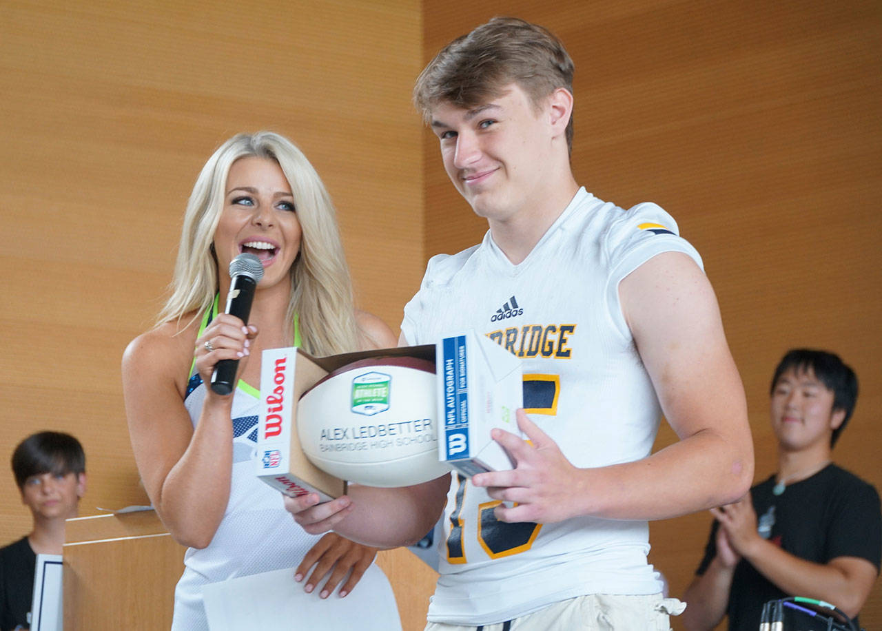 Luciano Marano | Bainbridge Island Review - Bainbridge High School senior QB Alex Ledbetter recieves a custom football during a ceremony last week when he was selected by the Seattle Seahawks and CenturyLink as this years first Seahawks and CenturyLink High School Athlete of the Week.