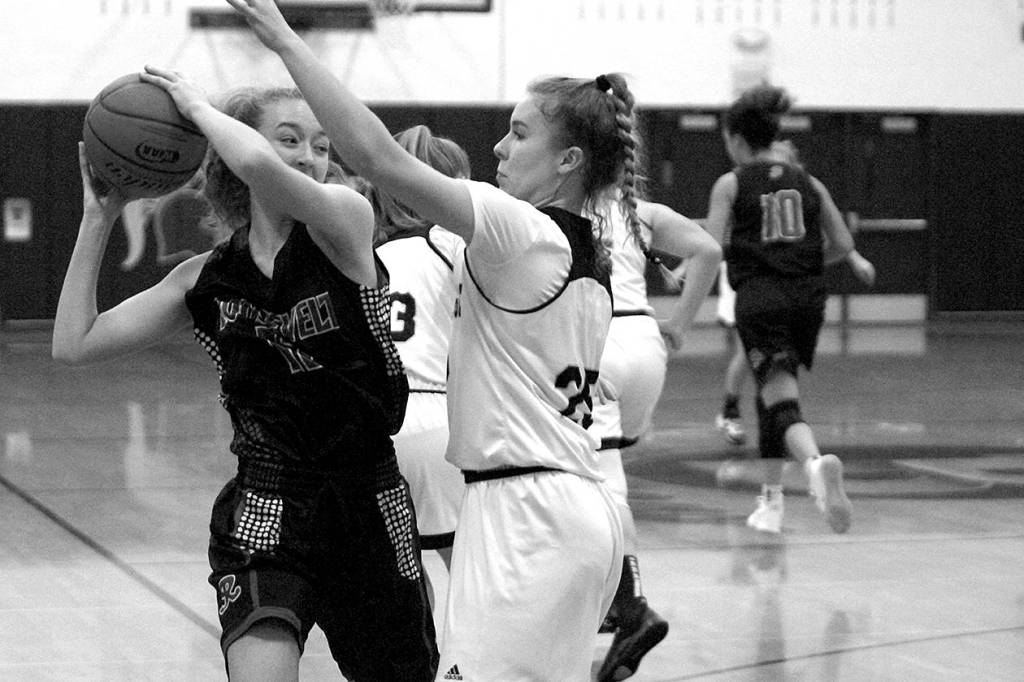 Luciano Marano | Bainbridge Island Review - The Bainbridge High varsity girls basketball team came up short against Roosevelt High School last Friday.                                 Luciano Marano | Bainbridge Island Review - Bainbridge Highs Paige Aichele attempts to block a shot during last Fridays game against Roosevelt.