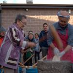Luciano Marano | Bainbridge Island Review - Kazuko Kay Sakai Nakao, who recently celebrated her 100th birthday, pounds steamed sweet rice at this years Bainbridge Island mochi tsuki event, with famed master mochi maker, and longtime unofficial face of the occasion, Shoichi Sugiyama.