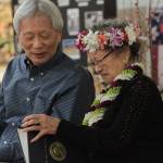 Kay Sakai Nokao admires a proclamation presented to her by Gov. Jay Inslee at her 100th birthday celebration as her son Bill Nakao looks on. (Brian Kelly | Bainbridge Island Review)