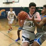 Luciano Marano | Bainbridge Island Review - Bainbridge High School sophomore Alexander Taylor attempts a three-pointer during last Fridays home game against Ingraham.                                 Luciano Marano | Bainbridge Island Review - Spartan sophomore James Carey attempts to work around an Ingraham defender near the net during last Fridays home game.