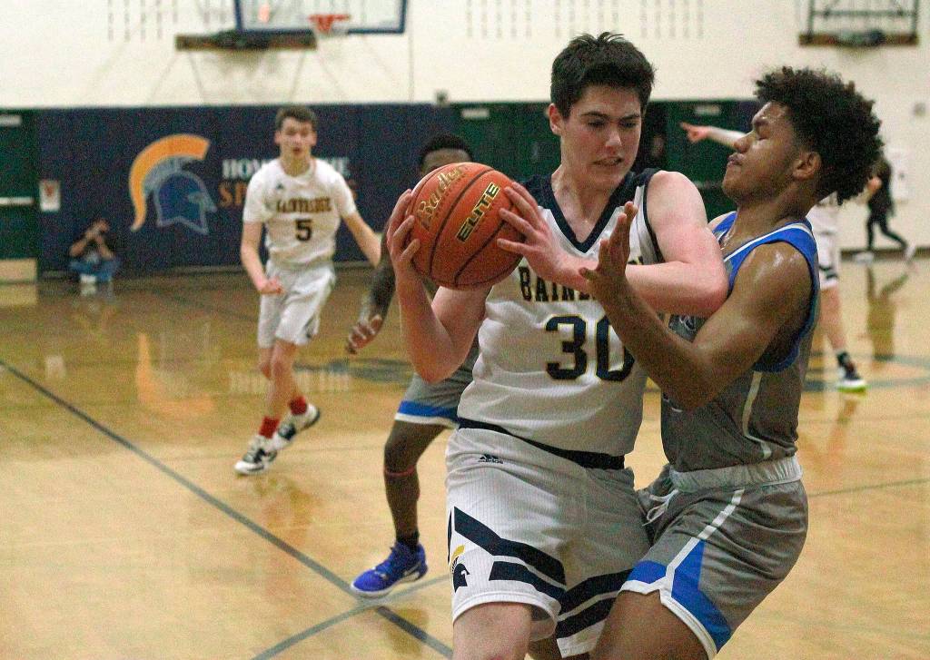 Luciano Marano | Bainbridge Island Review - Bainbridge High School sophomore Alexander Taylor attempts a three-pointer during last Fridays home game against Ingraham.                                 Luciano Marano | Bainbridge Island Review - Spartan sophomore James Carey attempts to work around an Ingraham defender near the net during last Fridays home game.