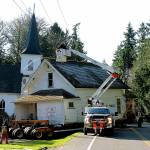 The 100-year-old parsonage home next to Port Madison Lutheran Church is moved off its lot Wednesday morning. (Brian Kelly | Bainbridge Island Review)