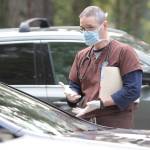Veterinarian Mark Swaney talks with a dog owner in the parking lot of the Day Road Animal Hospital. (Brian Kelly | Bainbridge Island Review)