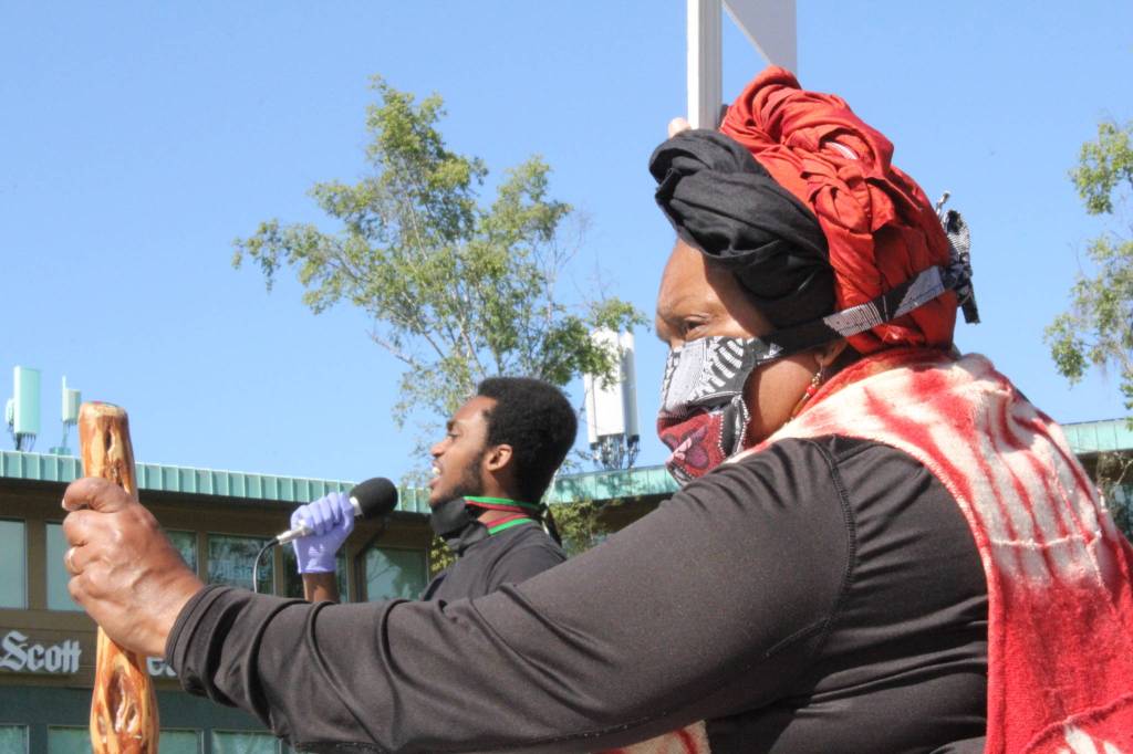 Karen Vargas of the Kitsap ERACE coalition looks on as protesters recite the names of men and women who have been killed in interactions with police officers. Photo by Nick Twietmeyer
